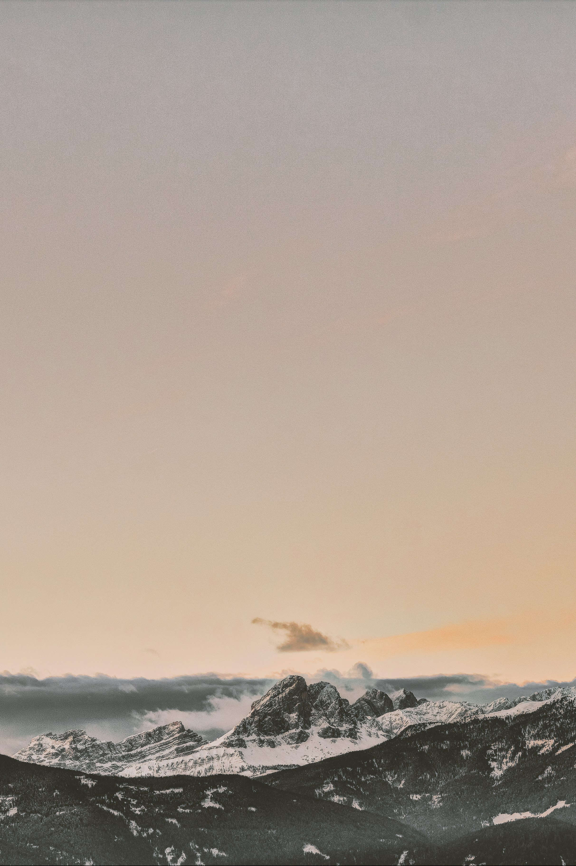 rock formation coated with snow under orange sky